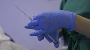 seringa nas mãos de um médico